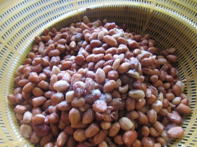 Salting washed groundnuts kept in a strainer